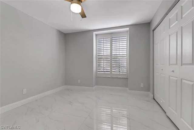 unfurnished bedroom featuring ceiling fan, light tile floors, and a closet