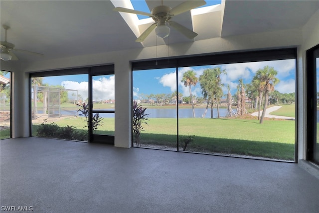 unfurnished sunroom featuring ceiling fan and a water view