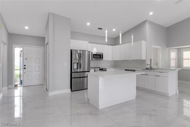 kitchen featuring white cabinets, a kitchen island, light tile flooring, and stainless steel appliances