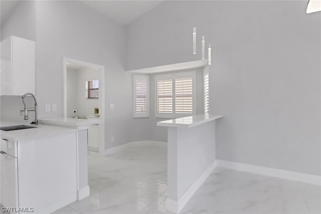 interior space featuring high vaulted ceiling, white cabinetry, sink, and light tile floors