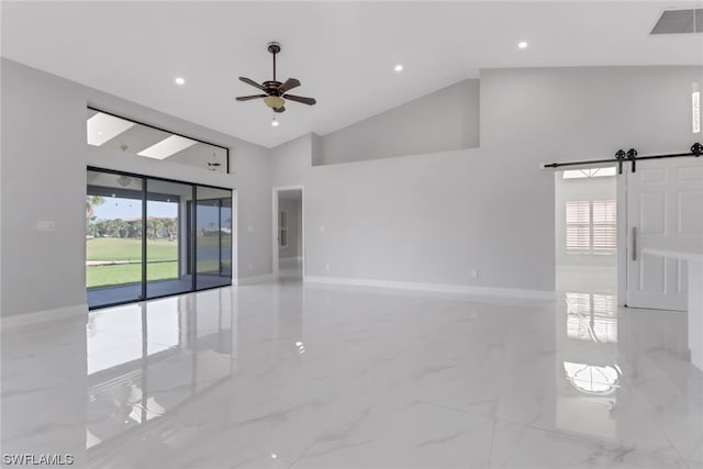 tiled spare room with high vaulted ceiling, a barn door, and ceiling fan