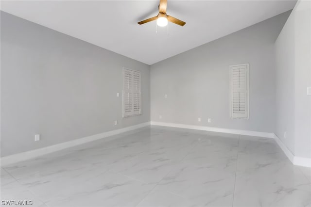 empty room with light tile flooring, lofted ceiling, and ceiling fan