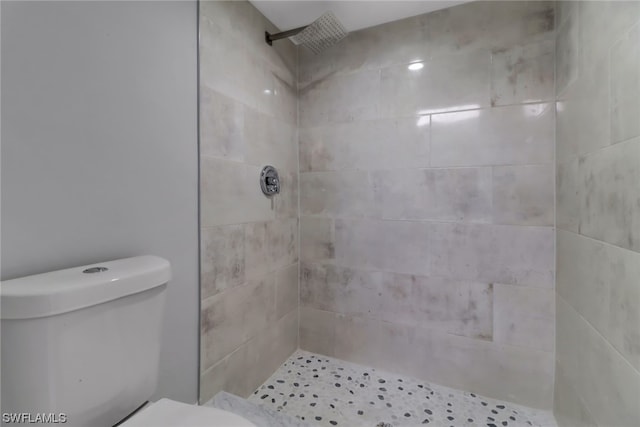 bathroom with toilet and tiled shower