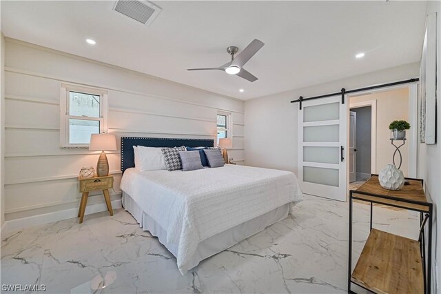 bedroom featuring a barn door and ceiling fan