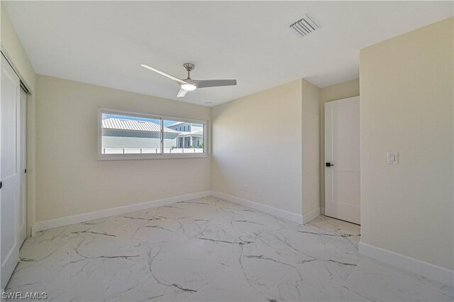 unfurnished bedroom with ceiling fan and a closet