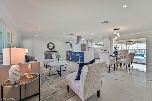 living room featuring ceiling fan, ornamental molding, and sink