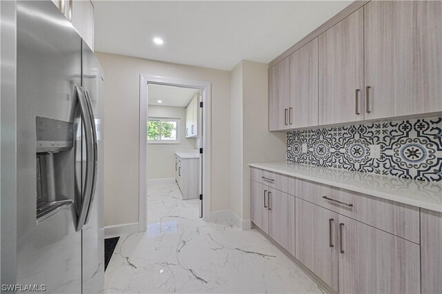 kitchen featuring stainless steel refrigerator with ice dispenser, tasteful backsplash, and light brown cabinetry