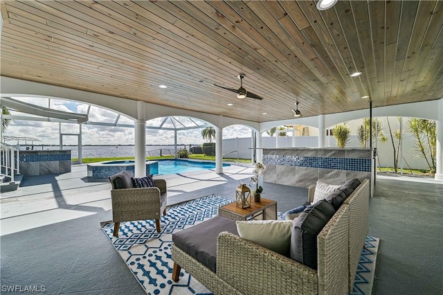 view of patio with glass enclosure and a pool with hot tub