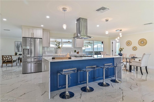 kitchen with island exhaust hood, stainless steel fridge, crown molding, and pendant lighting