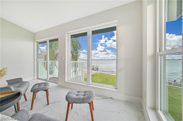 interior space with a water view, vaulted ceiling, and plenty of natural light