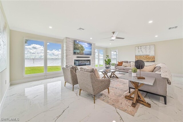 living room featuring a large fireplace, ceiling fan, and ornamental molding