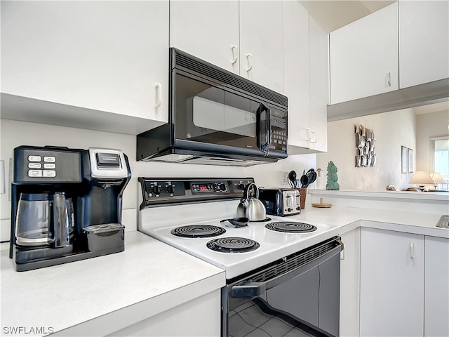 kitchen with white cabinetry, tile flooring, and electric range