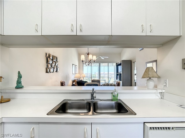 kitchen with white cabinets, a notable chandelier, and sink