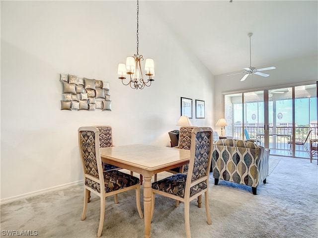 dining room with high vaulted ceiling, ceiling fan with notable chandelier, and light colored carpet