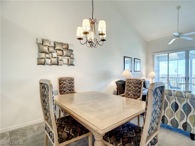 dining room featuring light carpet, high vaulted ceiling, and ceiling fan with notable chandelier