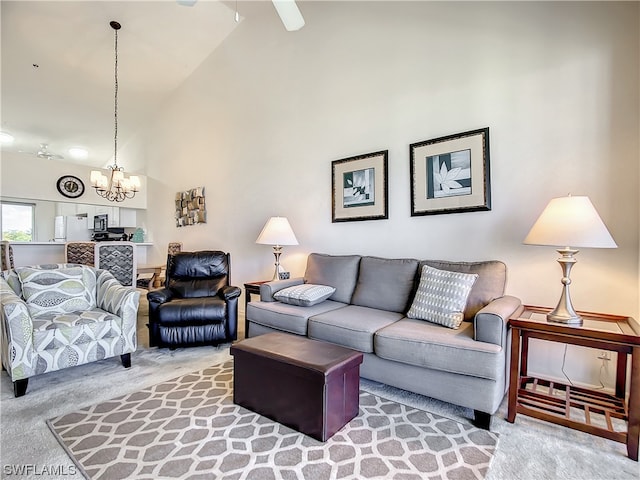 carpeted living room featuring high vaulted ceiling and ceiling fan with notable chandelier