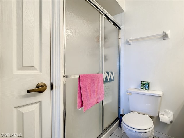 bathroom with toilet, tile floors, and an enclosed shower