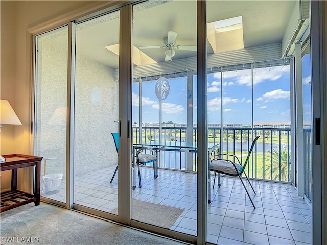 doorway featuring light tile flooring, a water view, and ceiling fan