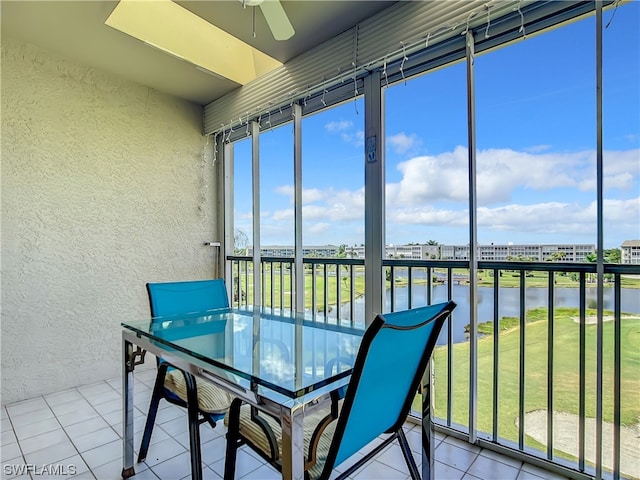 unfurnished sunroom with a water view and ceiling fan