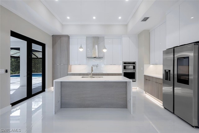 kitchen with french doors, sink, white cabinets, appliances with stainless steel finishes, and wall chimney range hood