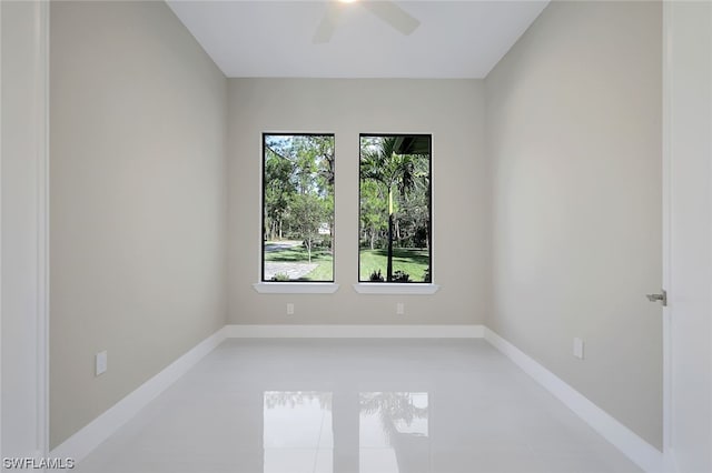 unfurnished room with ceiling fan, light tile floors, and a wealth of natural light