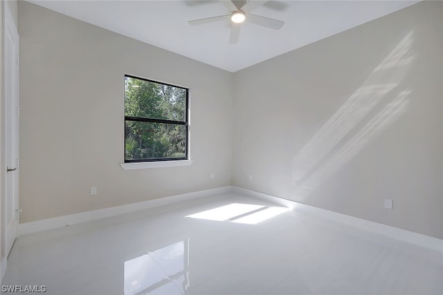 tiled spare room with ceiling fan