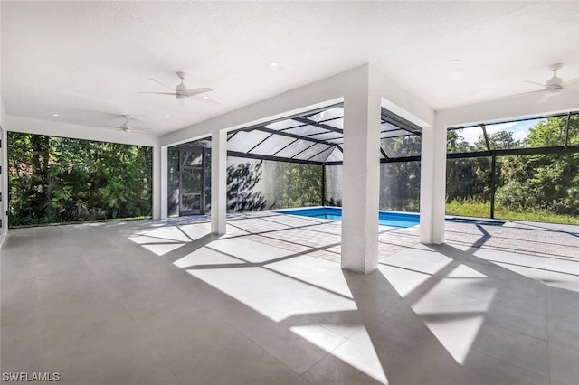 unfurnished sunroom featuring ceiling fan