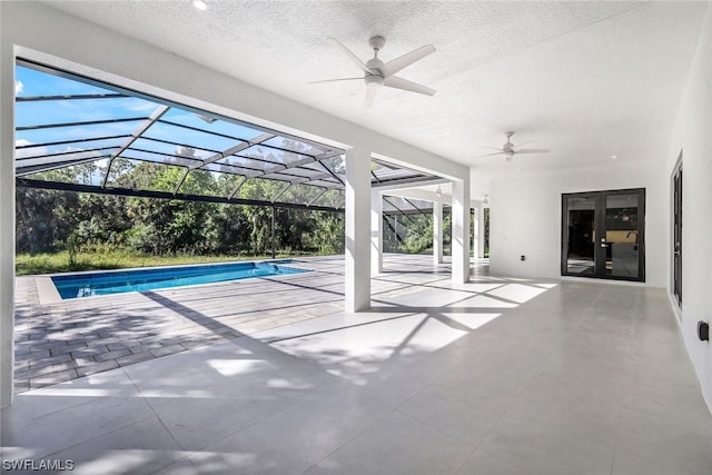 view of pool with a patio area, glass enclosure, and ceiling fan