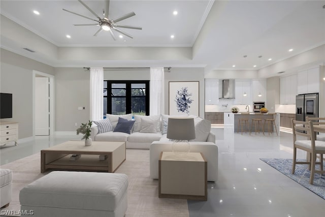 tiled living room featuring ornamental molding, ceiling fan, and sink