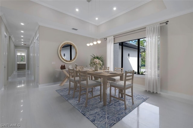 dining room with a raised ceiling, light tile flooring, and ornamental molding