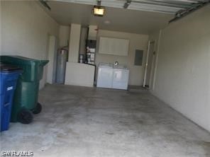 garage featuring washing machine and dryer and water heater