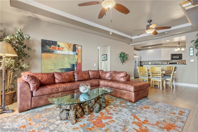 living room with light tile floors, a tray ceiling, ceiling fan, and ornamental molding