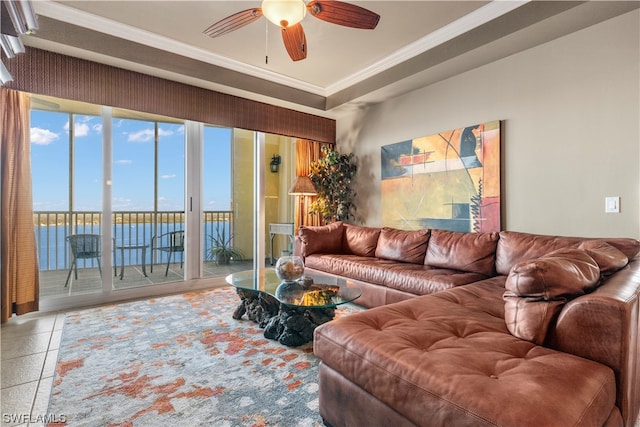 tiled living room featuring crown molding, a water view, and ceiling fan