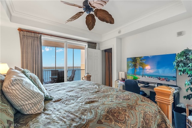 bedroom featuring access to exterior, ceiling fan, ornamental molding, a water view, and a raised ceiling