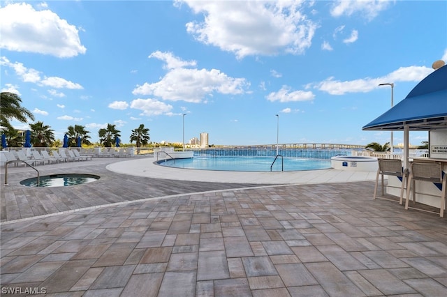 view of pool featuring a community hot tub and a patio