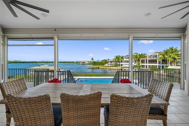 sunroom with a water view and ceiling fan