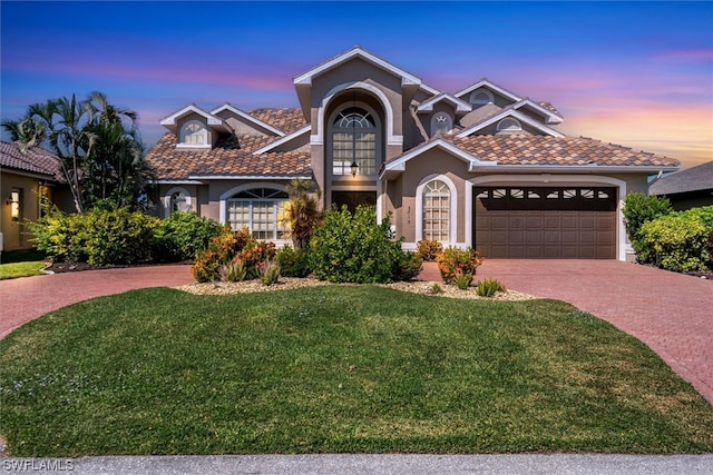 view of front of house with a garage and a lawn