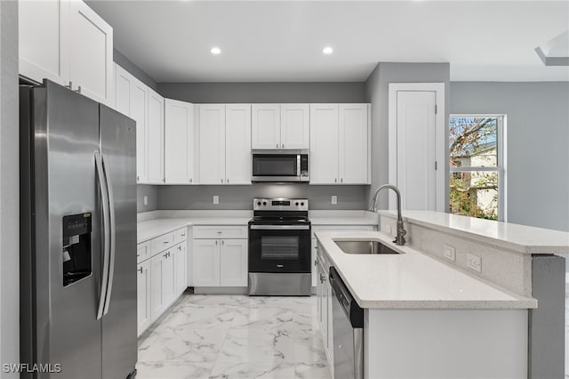 kitchen featuring white cabinets, sink, light stone countertops, appliances with stainless steel finishes, and kitchen peninsula