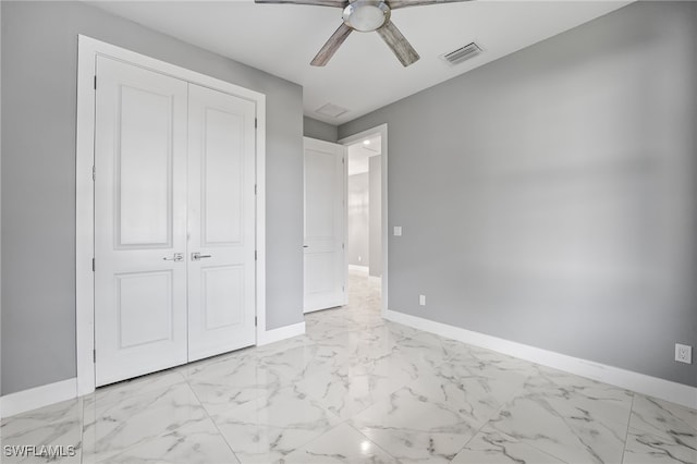 unfurnished bedroom with ceiling fan and a closet