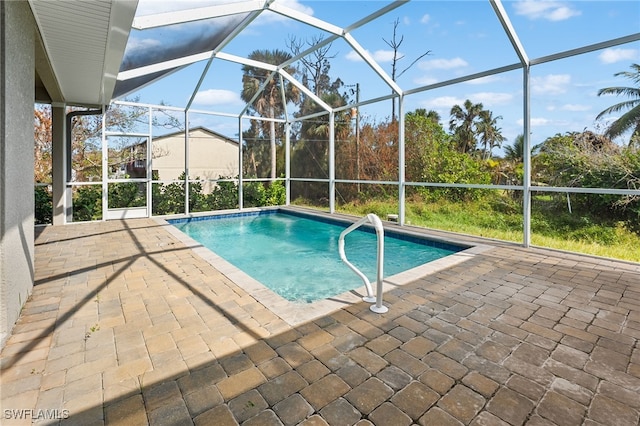 view of pool featuring glass enclosure and a patio area