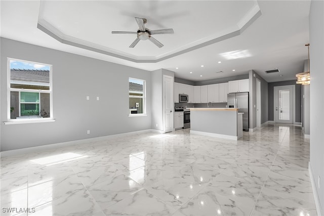 kitchen featuring white cabinets, a kitchen island, stainless steel appliances, and a wealth of natural light