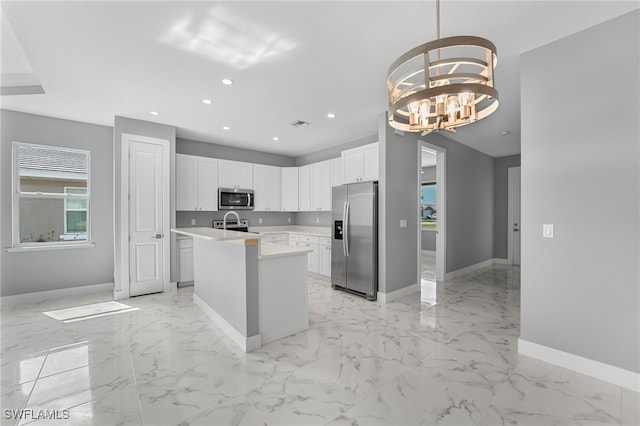 kitchen featuring a kitchen island with sink, an inviting chandelier, white cabinets, hanging light fixtures, and stainless steel appliances