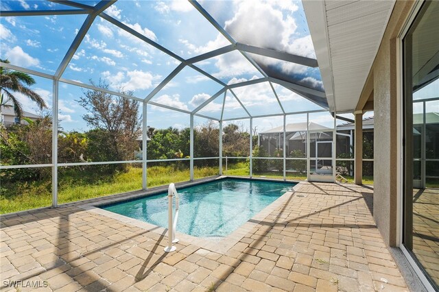 view of swimming pool with glass enclosure and a patio