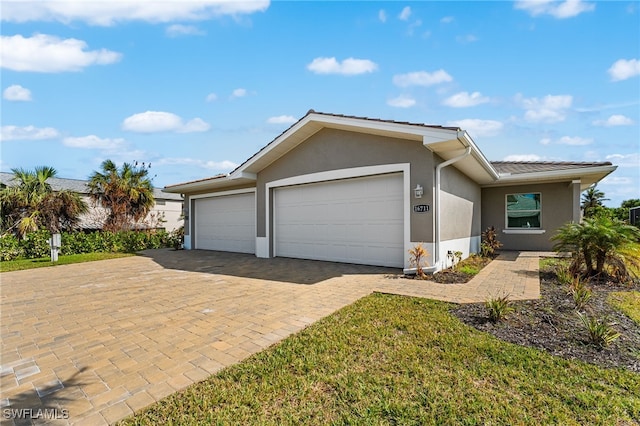 ranch-style home with a garage and a front lawn