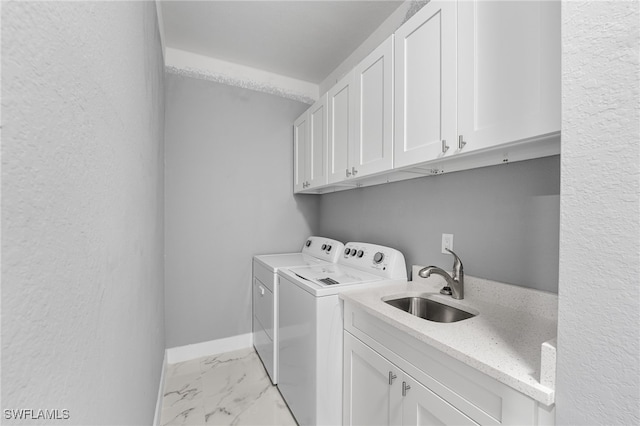 washroom with cabinets, independent washer and dryer, and sink