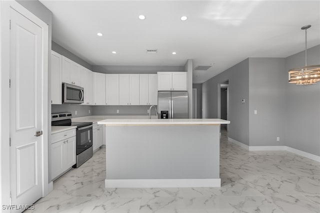 kitchen with decorative light fixtures, stainless steel appliances, white cabinetry, and an island with sink