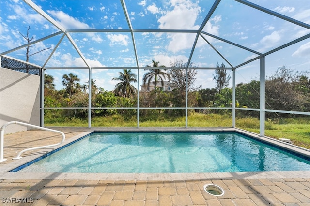 view of swimming pool featuring a patio and glass enclosure