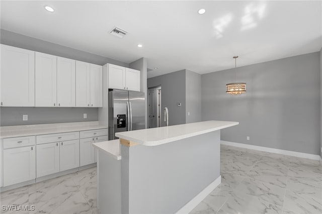 kitchen featuring white cabinetry, hanging light fixtures, a notable chandelier, stainless steel fridge, and an island with sink