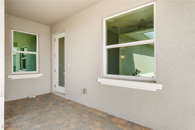 property entrance with ceiling fan and a patio area