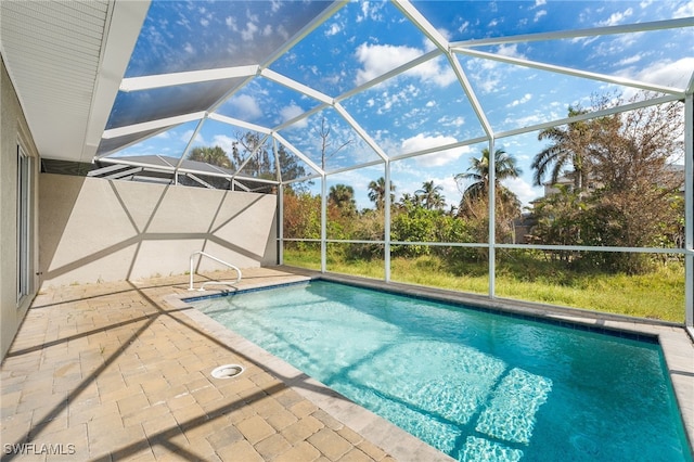 view of swimming pool with glass enclosure and a patio